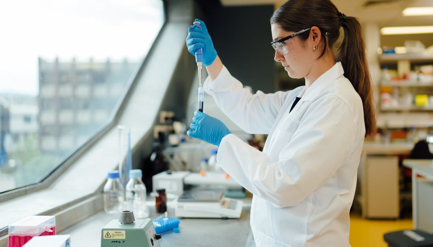 Scientist pipetting into test tube