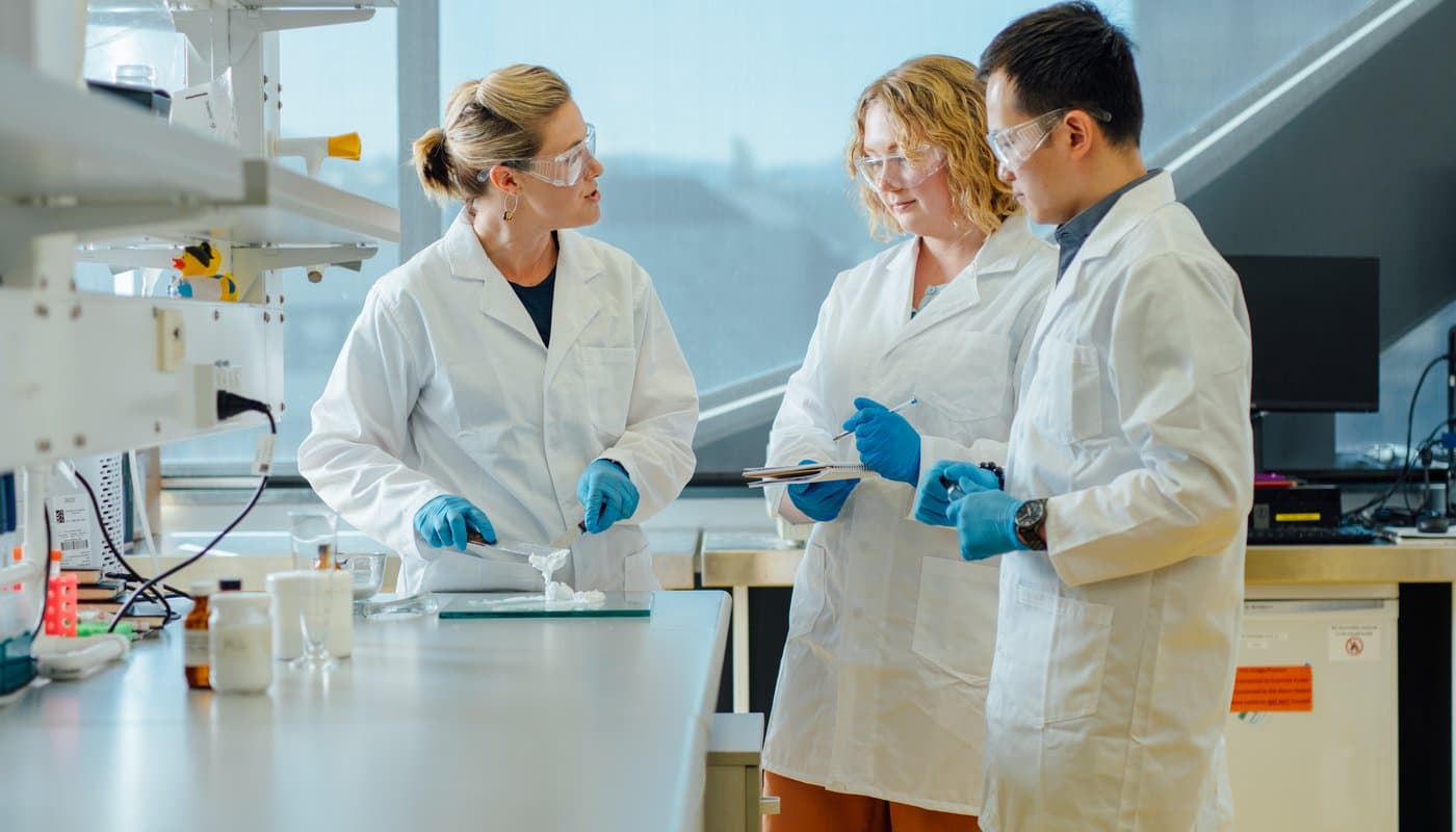 Medical students wearing labcoats in a research laboratory