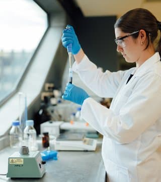 Scientist pipetting into test tube